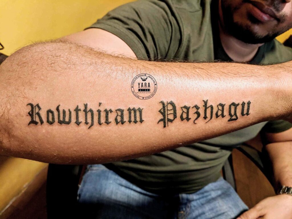 The image shows a Motivational quote tattoo “Rowthiram Pazhagu” (Practice Anger) on a man’s hand.
