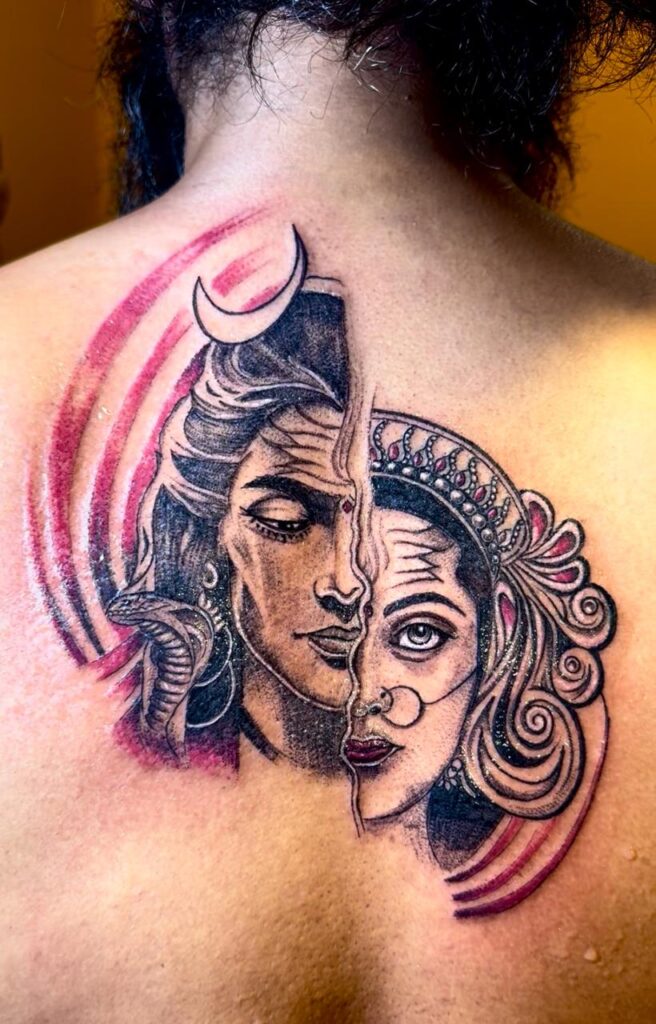 The image shows an elaborate customized tattoo at the back, featuring half face of lord shiva and half face of Goddess Parvathi into one.